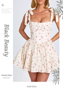 Detail of white floral dress featuring bow shoulder straps and a corset bodice design