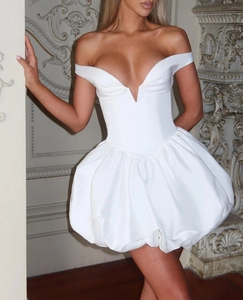 Detail of the white off-shoulder puff mini dress featuring a deep V-neckline and corset waist