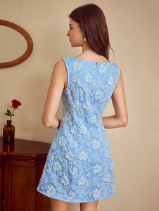 Détail de la robe trapèze bleu clair avec broderies florales 3D et fermeture éclair au dos