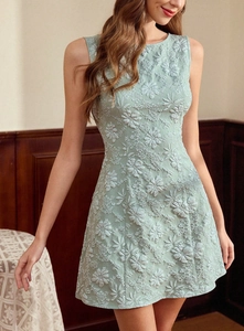 Détail de la dentelle florale vert clair sur une robe de cocktail bustier de coupe trapèze