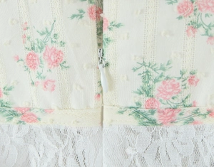 Détail macro d'une fermeture éclair invisible sur une robe florale avec dentelle et texture