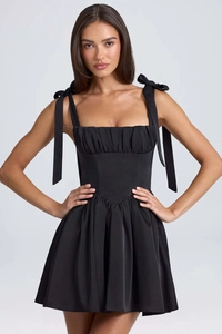 Detailed view of square neck black dress with ruffled bodice and bow shoulder straps