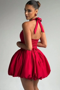 Detail of red satin halter dress showing back tie-up ribbon and voluminous balloon hemline