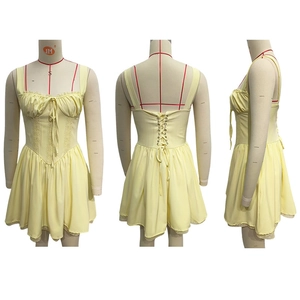 Detail of light yellow lace hem and lace-up back corset design on sundress