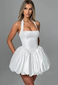 Detail of white corset-style halter dress with pleated bubble skirt and satin sheen