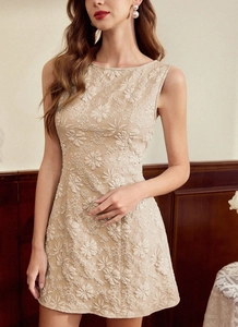 Détail d'une robe sans manches beige avec broderie florale 3D et décolleté rond élégant