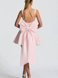 Robe courte rose dos nu avec un grand nœud décoratif et de fines bretelles