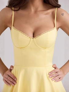 Elegant light yellow bustier dress with lace trim and spaghetti straps in a retro style