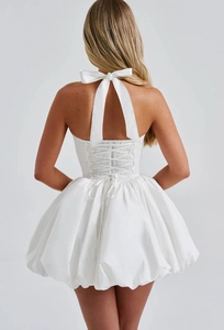 Detailed back view of white halter bubble dress featuring a large bow and lace-up design