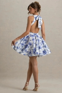 Détail d'une mini robe dos nu à fleurs bleues avec un nœud décoratif au niveau du cou