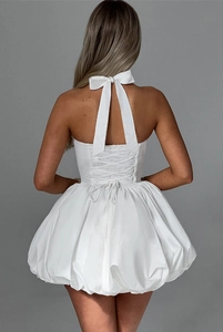 Detailed back view of white halter bubble dress with bow tie and lace-up corset detail