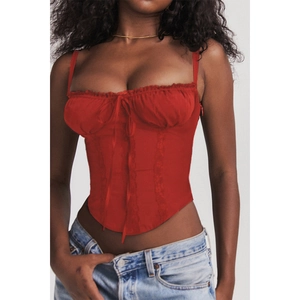 Close-up of red lace-up corset top with bow detail and ruffled hem on model