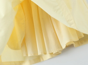 Vista macro dell'orlo del vestito giallo chiaro con cuciture precise e strati multipli