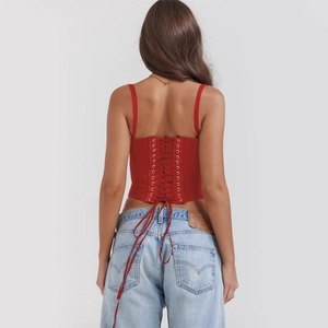 Close-up of red corset top back with lace-up metal eyelets and adjustable straps