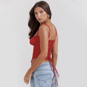 Rear view of red lace-up corset top with criss-cross back ties and light wash jeans