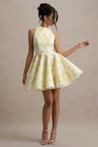 Détail d'une robe blanche à fleurs jaunes, avec col montant et jupe évasée en ligne A