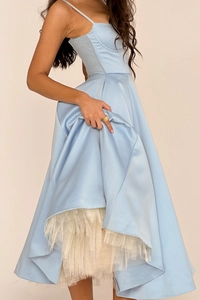 Détail d'une robe en satin bleu clair avec taille haute évasée et plusieurs couches de tulle