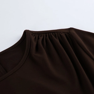 Detailed view of dark brown knit dress featuring gathered shoulder and pleated neckline