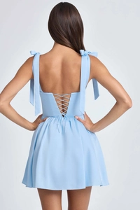 Detail of the sky blue mini dress featuring a lace-up corset back and bow tie straps