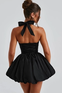Detail of a black halter bubble dress featuring a large bow and adjustable drawstring back