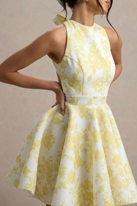 Détail de la robe trapèze à fleurs blanches avec un grand nœud élégant à l'arrière