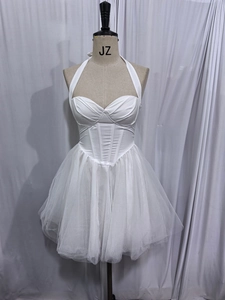 Detailed view of white halter corset dress with multi-layered fluffy tulle skirt and sweetheart neckline
