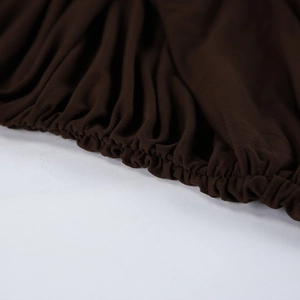 Close-up of deep brown ruched fabric detailing with elasticated waist and stitching