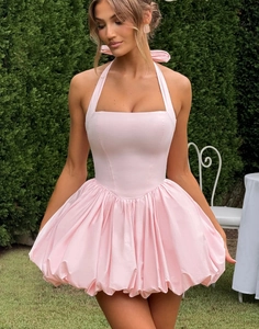 Close-up detail of light pink halter mini dress featuring a large bow and puff bubble skirt