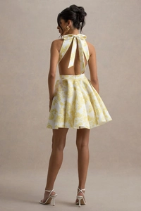Vue détaillée d'une robe courte fleurie dos nu avec grand nœud et imprimé floral jaune