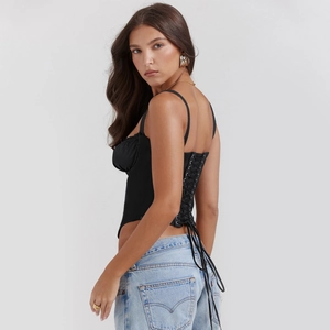 Detailed back view of black corset top with intricate lace-up ties and slim fit design