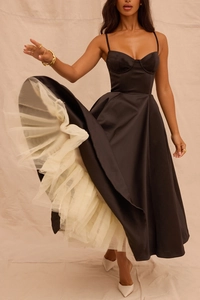 Détail du corsage à fines bretelles et jupon en maille multicouche sur une robe noire chic
