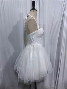 Detail view of white halter neck corset dress featuring lace patchwork and lace-up back