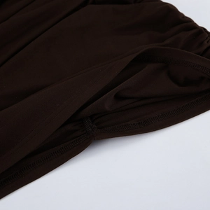 Macro shot of precise overlock stitching and ruched fabric on dark brown knit dress