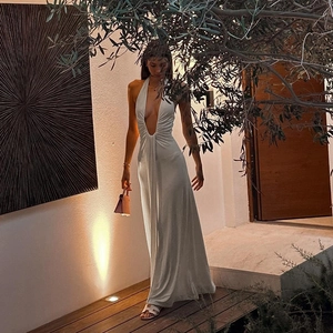Detail of white halter neck maxi dress with deep V-neck and luxurious silk-like texture