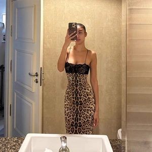 Detailed view of leopard print dress featuring black lace patchwork and camisole straps