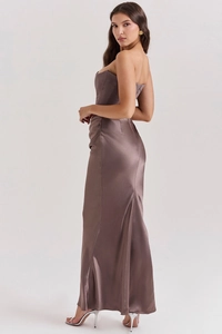 Macro detail of glossy satin fabric and elegant fishtail hem on the mocha party dress