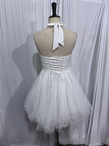 Detail of white satin bodice with cross-strap lace-up back and layered mesh tutu skirt
