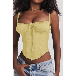 Detail of light yellow corset top with lace trim, thin straps and front tie closure