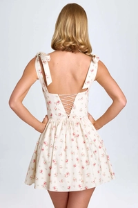 Close-up of lace-up back detail and floral print on white summer dress