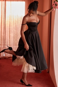 Détail de la robe bustier noire élégante avec jupon en maille blanche et finition satinée