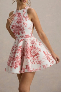 Détail d'une robe trapèze avec motifs floraux rouges et texture du tissu plissé de la jupe