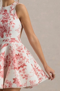 Détail d'une robe trapèze blanche à fleurs avec motifs d'oiseaux rouges et fleurs à la taille