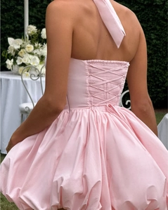 Detailed back view of a pink halter neck bubble dress with lace-up corset design