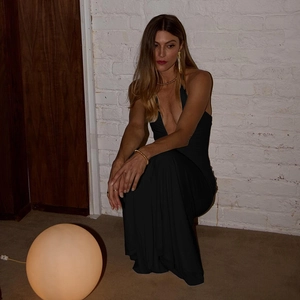 Detail view of the elegant deep V-neck and open back on a sleek black formal maxi dress