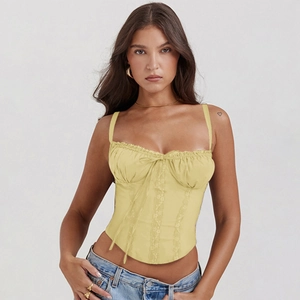Detailed view of yellow lace-up camisole top with delicate bows and corset style trim