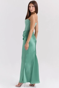 Close-up of sage green satin fabric with elegant waist pleats and shiny finish