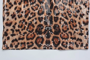 Detail of leopard print fabric with shimmering sequins and premium stitched hemline