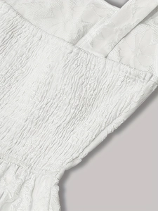 Gros plan sur le tissu jacquard blanc avec texture florale et détails élastiques froncés