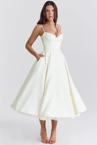 Détail d'une robe midi en satin ivoire avec corsage structuré et poches latérales