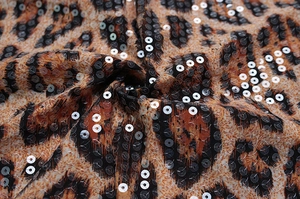 Close-up of leopard print fabric with shimmering sequins and detailed stitching texture